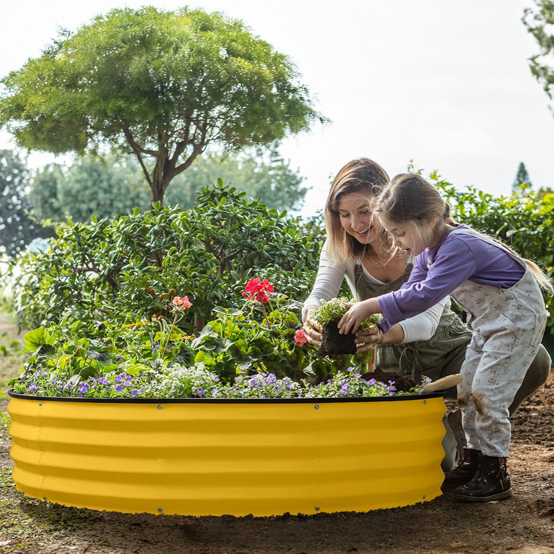 mother and child planting with a yellow galvanized raised garden bed