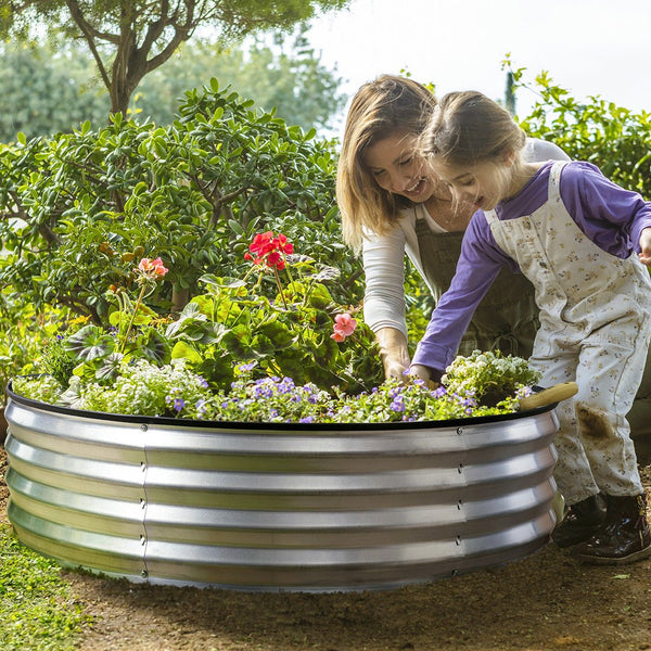 galvanized round planter with child planting