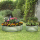 galvanized round planter on grass with flowers and plants