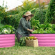woman planting with a metal raised garden bed