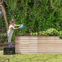 child watering raised garden beds outdoor