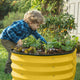 galvanized raised garden bed with child planting