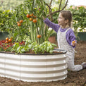 child planting with a galvanized raised garden bed 6x3x1