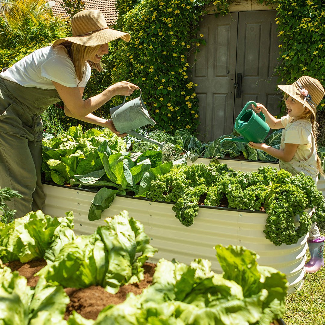 mother and child watering a raised garden bed